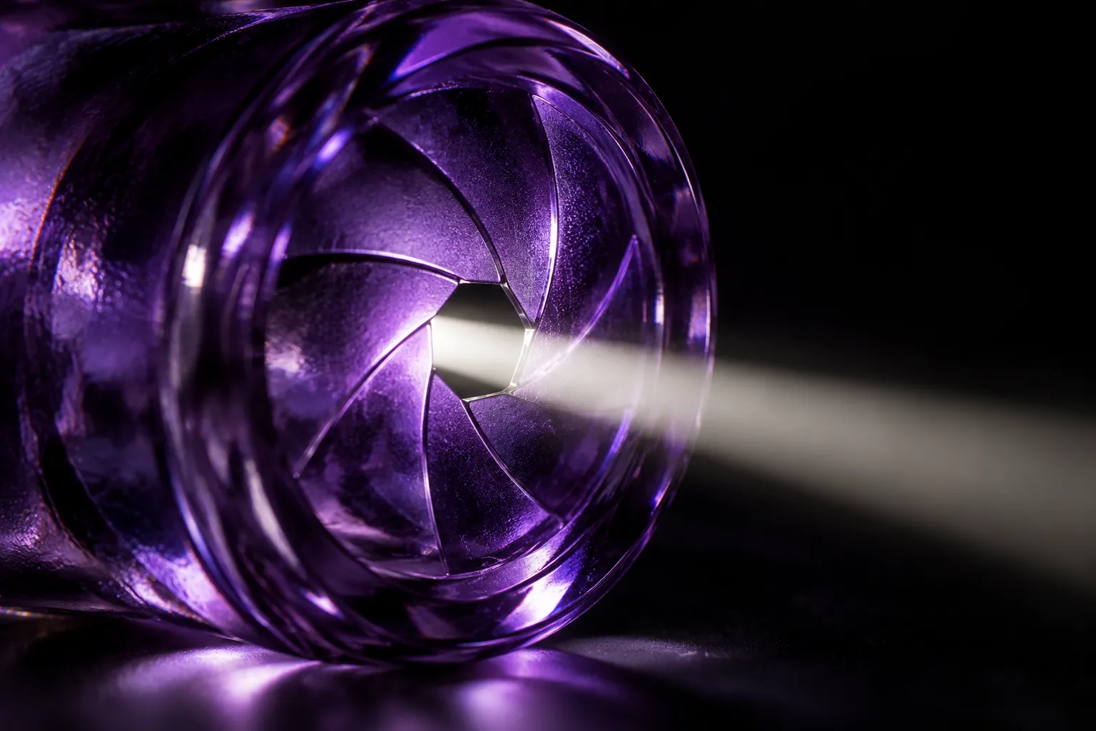 Purple glass aperture with a narrow beam of light against black