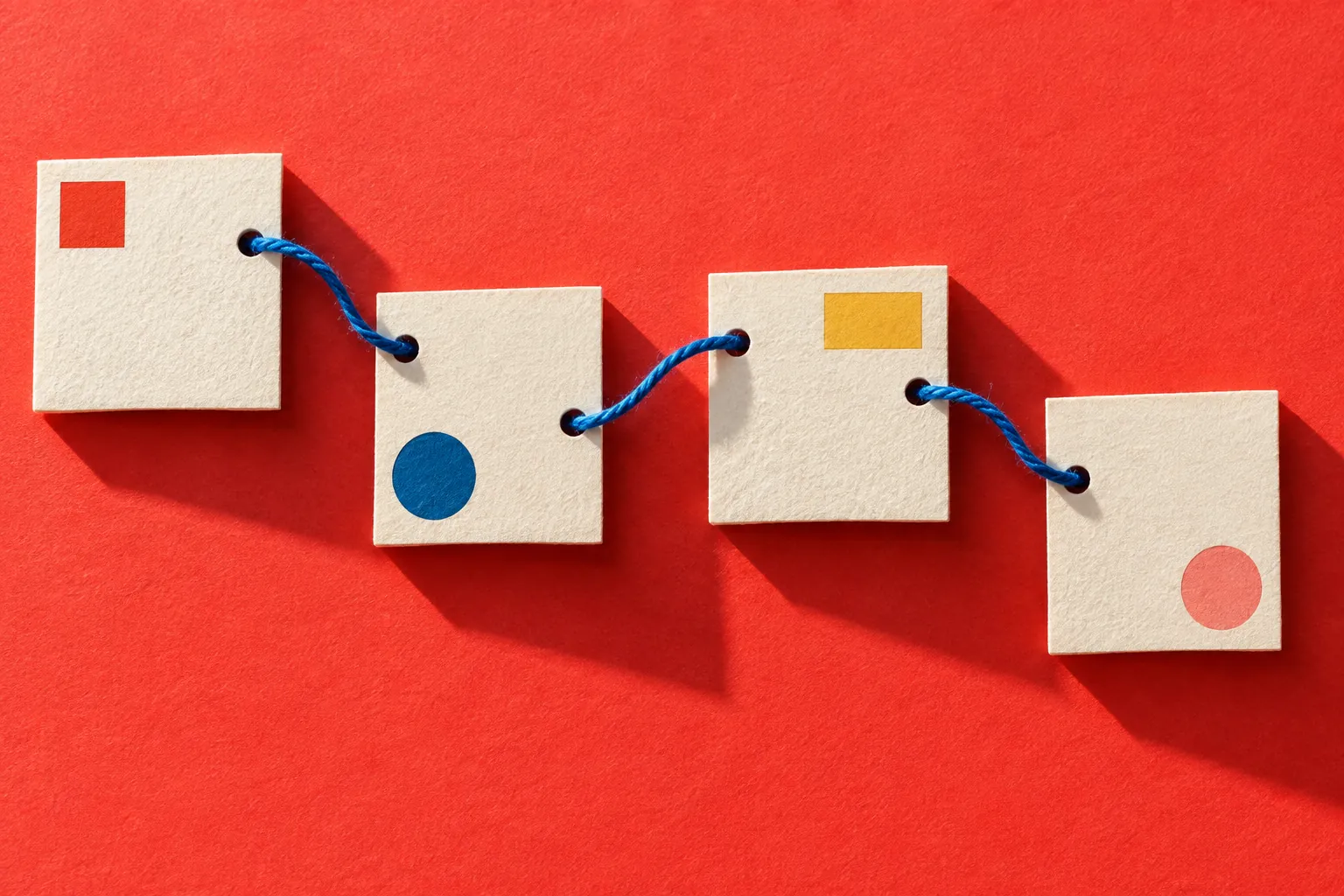 Conceptual blank cards joined by a blue thread, illustrating links between separate pages